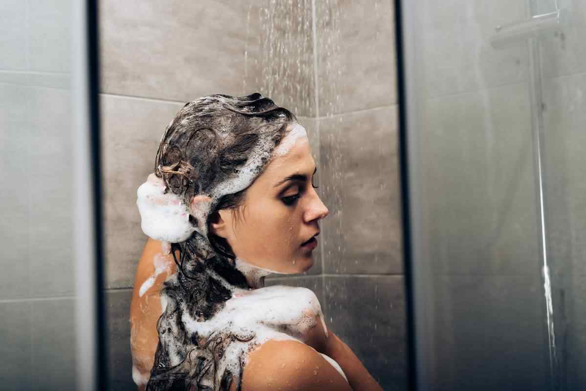 Woman washing her hair with caffeinated shampoo