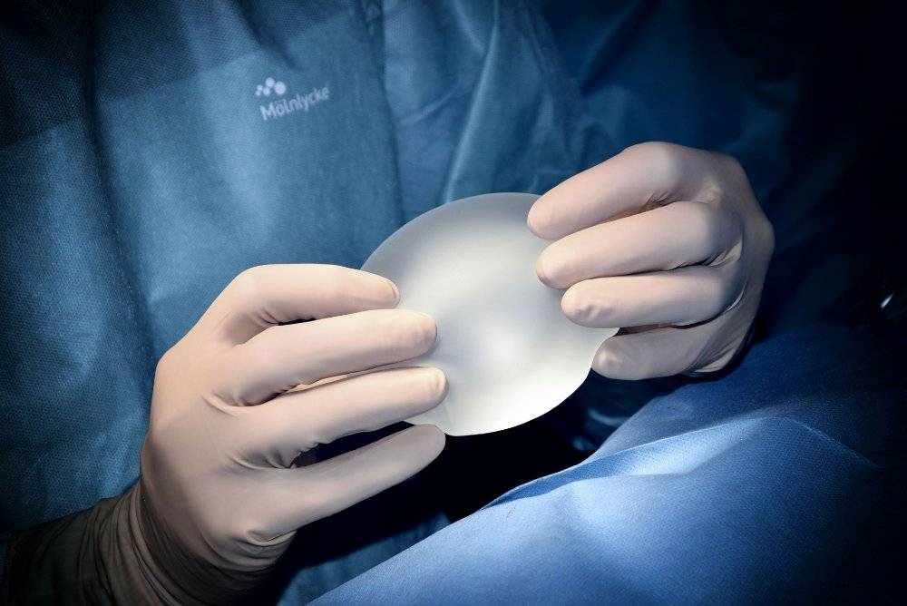 Plastic surgeon with a breast implant