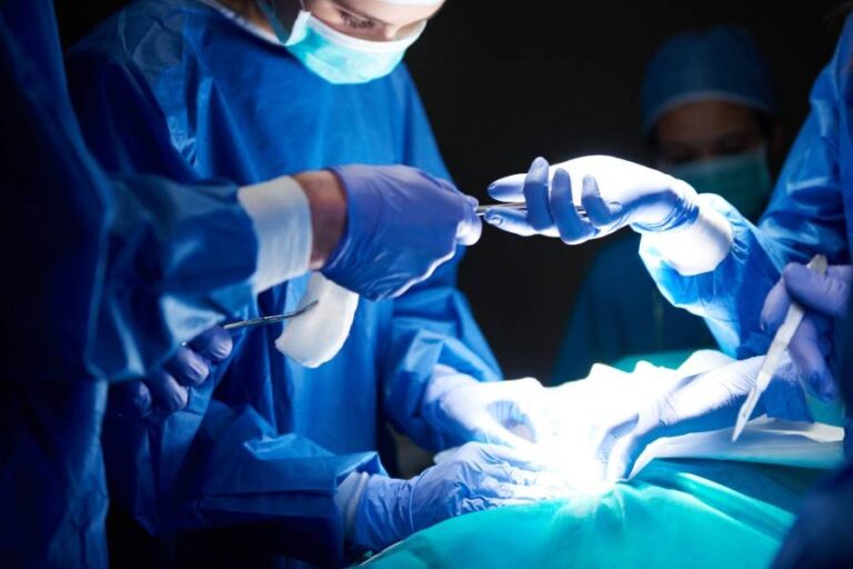 Médicos realizando una cirugía plástica a una paciente