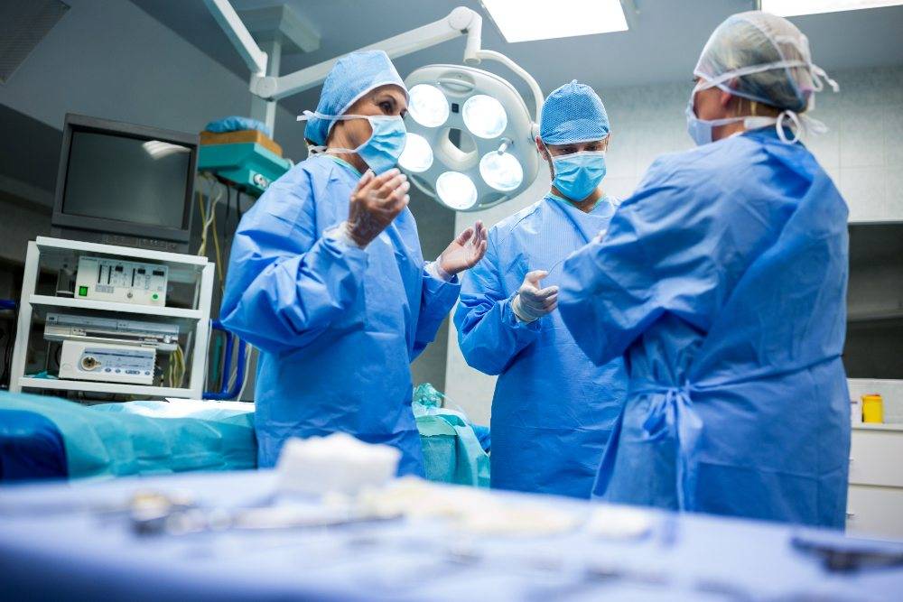 Los cirujanos de cirugia plastica en mexico que interactúan entre sí en la sala de operación