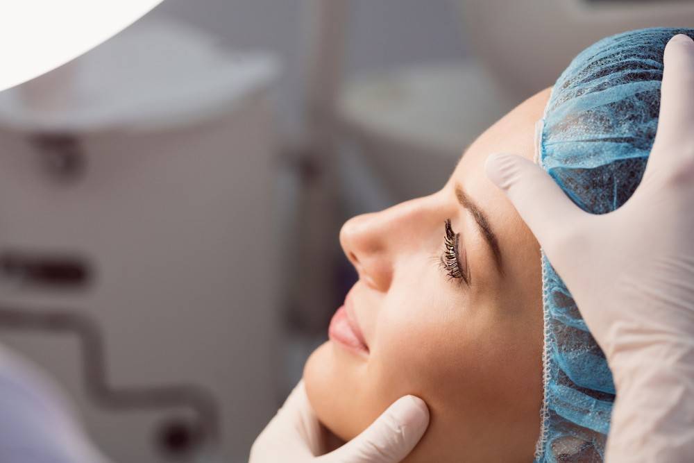 Doctor examinando la cara de la mujer para su cirugia plastica en mexico