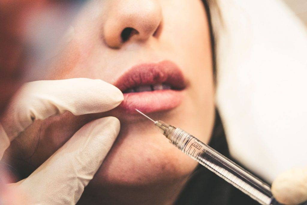 Doctor applying Botox on a patient’s lips