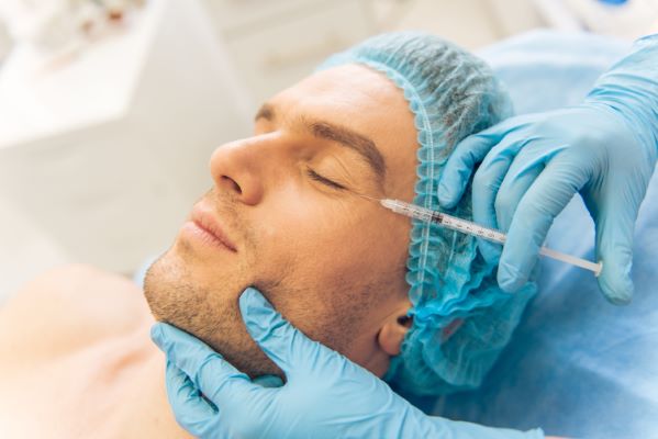 Plastic surgery; Young man being admitted to a clinic.