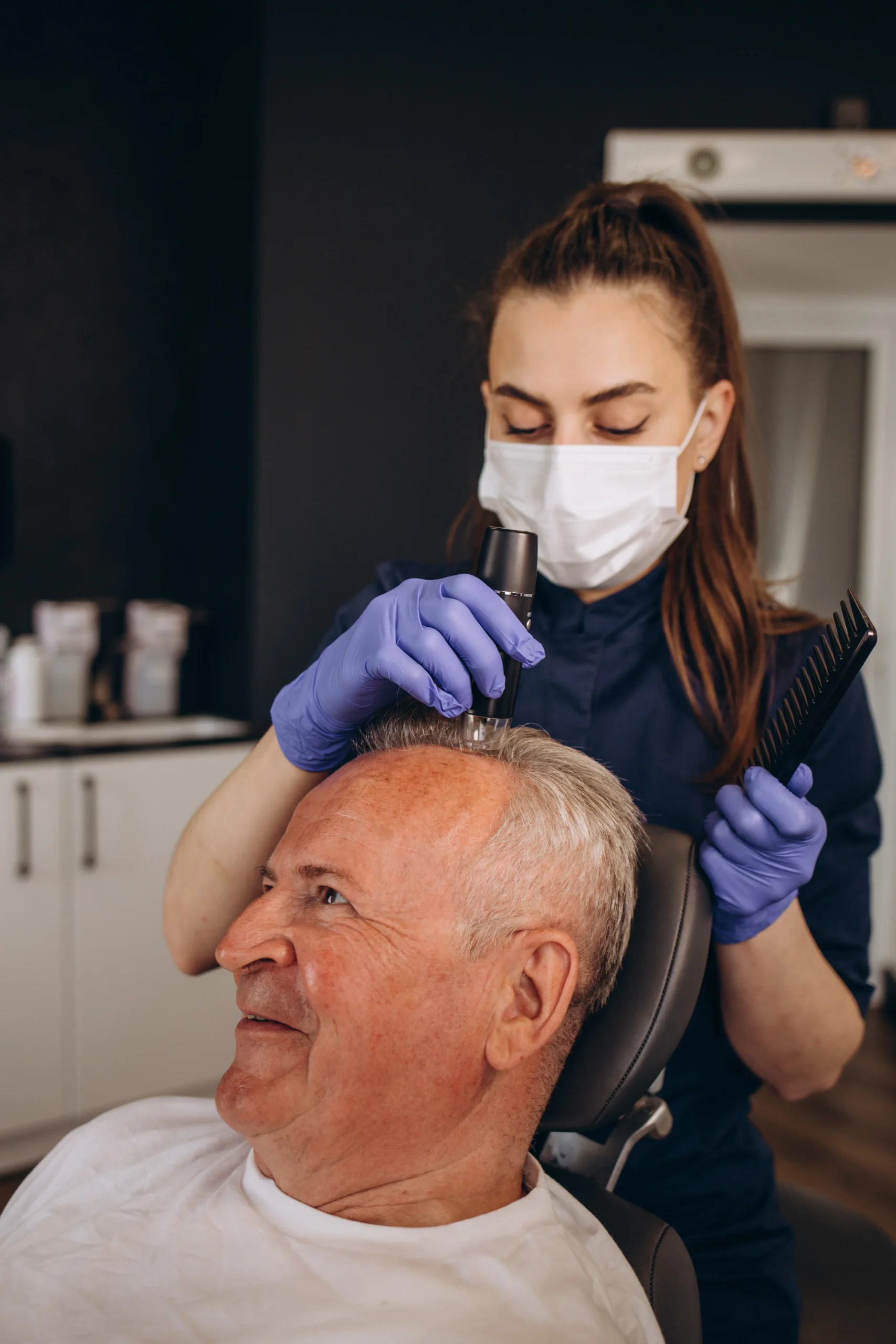 Surgeon providing care during a FUE hair transplant on an elderly patient, ensuring the hair restoration is natural and effective.