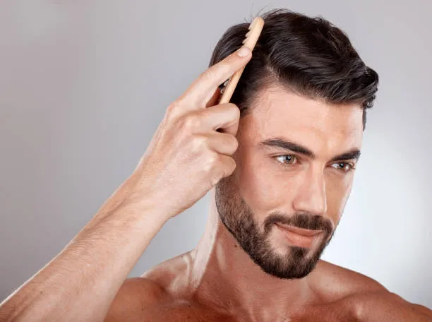 Man combing his hair, showcasing healthy and natural hair growth after hair transplant results