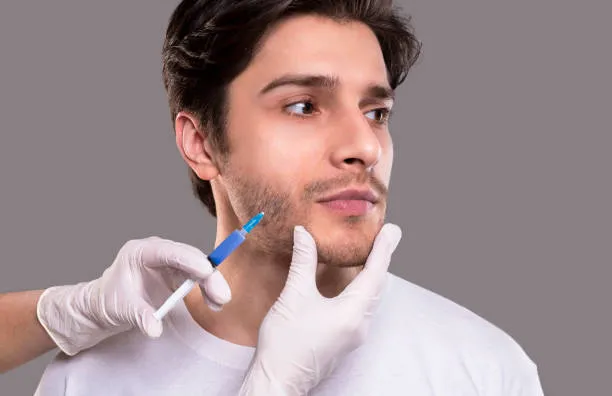 Man receiving targeted injections in his beard area during a professional procedure designed for facial hair transplant with natural results.
