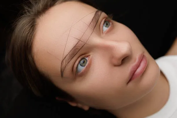 Doctor measuring eyebrow symmetry after eyebrow hair transplant procedure to ensure balanced, aesthetic, and natural-looking results.