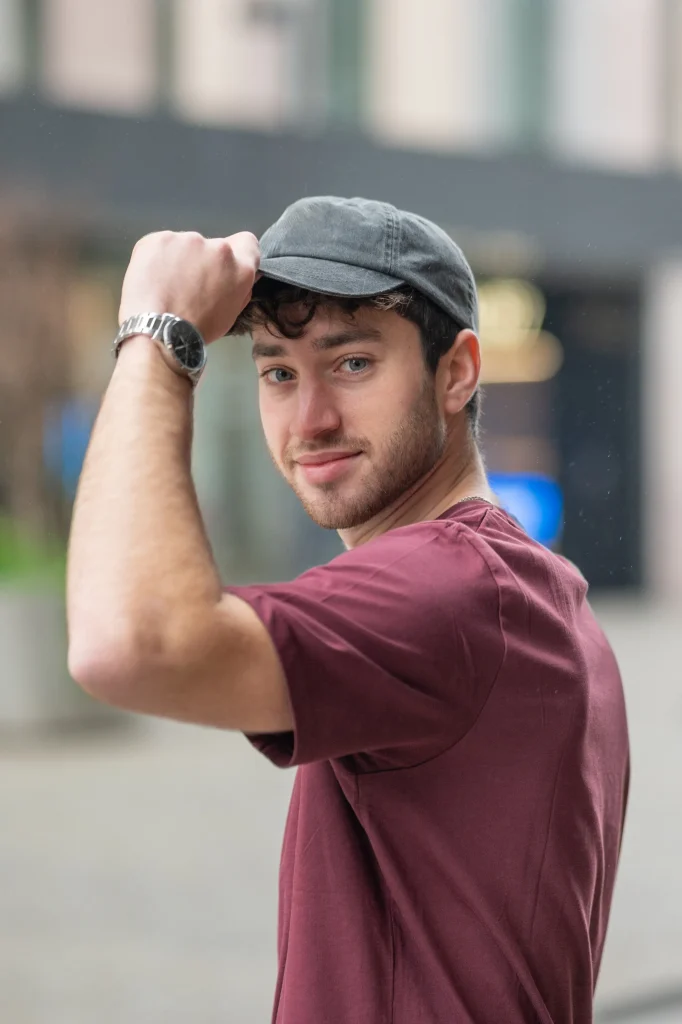 Close-up of a man wearing a mesh trucker cap. Can wearing hats cause hair loss or create traction alopecia issues?