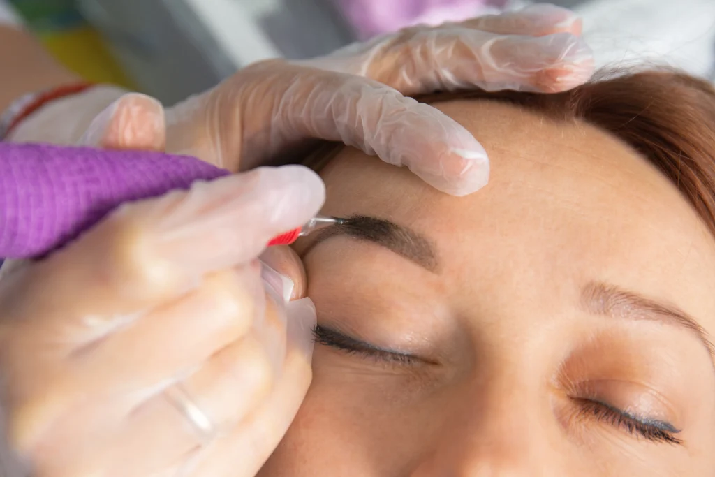 Microblading session on a patient, often compared as an alternative to a permanent eyebrow hair transplant.