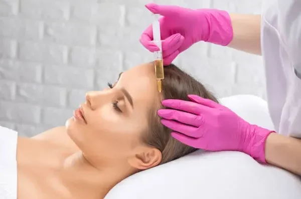 PRP hair procedure performed on a young woman as a non-surgical alternative to improve hair density