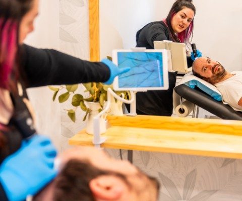 Specialist shows scalp analysis to patient at a hair transplant clinic.